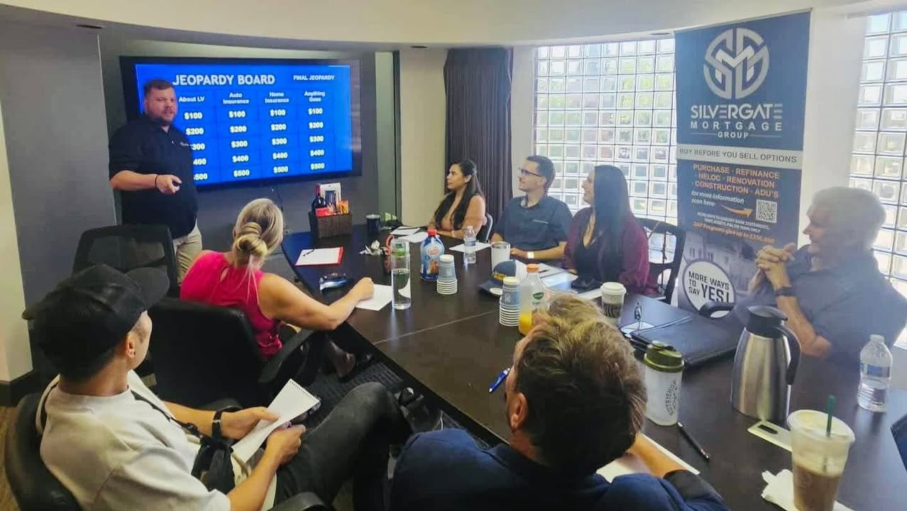 The group playing a Jeopardy-style round during a meeting