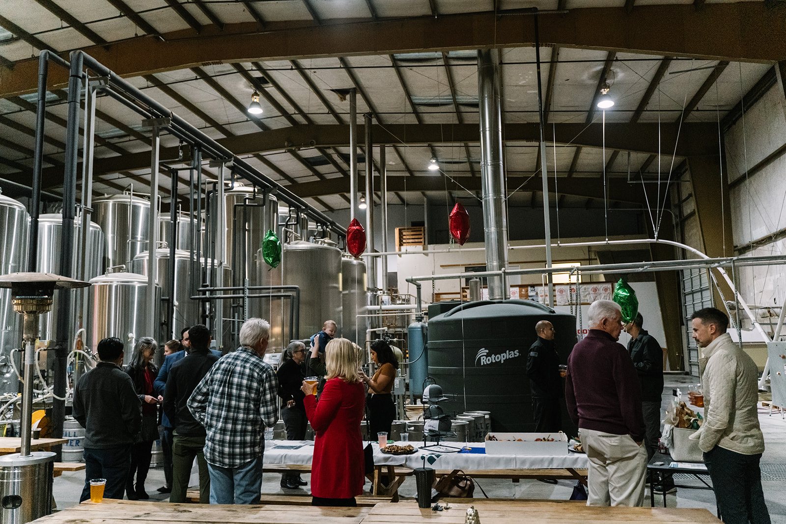 Guests gathered among the brewery tanks at the Legacy Christmas mixer