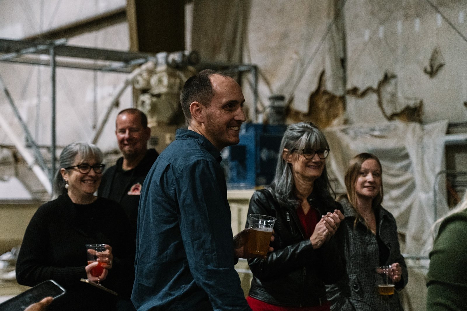 Three guests laughing together, drinks in hand